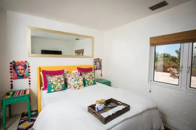 a bedroom with a bed with a mirror on the wall at Private Hacienda with Heated Pool and Spa with Amazing Views in Del Mar