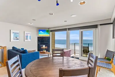 a living room with a table and a blue couch at A Wave From It All in Carlsbad