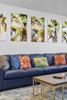 a blue couch in a room with palm trees at Bay View Dream - Steps to Bay, Rooftop Patio & AC in San Diego
