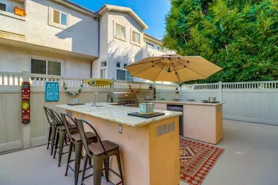 an outdoor bar with chairs and an umbrella at Bay View Dream Home - IndoorOutdoor Living, Rooftop & Steps to Bay in San Diego
