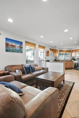 a living room with couches and a table and a kitchen at Bay View Dream Home - IndoorOutdoor Living, Rooftop & Steps to Bay in San Diego