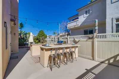 a patio with a bar and stools on a balcony at Bay View Dream Home - IndoorOutdoor Living, Rooftop & Steps to Bay in San Diego