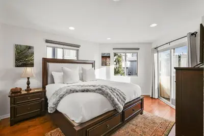 a bedroom with a large bed and windows at Bay View Dream Home - IndoorOutdoor Living, Rooftop & Steps to Bay in San Diego