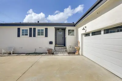 a white house with a garage and a driveway at Spacious Home with Yard about 7 Mi to Dtwm San Diego! in San Diego