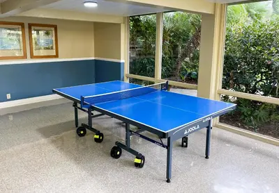 a blue ping pong table in a room with windows at Brooks Beach Vacations Villa C205 Oceanside in Oceanside