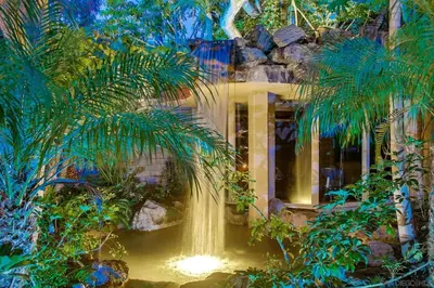 a waterfall in the middle of a garden with trees at Brooks Beach Vacations House B222 Oceanside in Oceanside