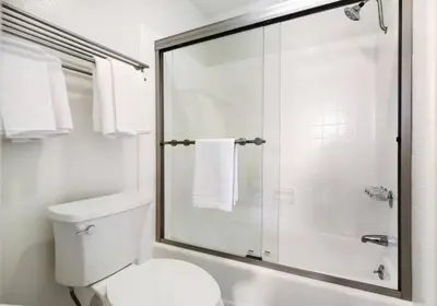 a white bathroom with a shower and a toilet at Brooks Beach Vacations House B222 Oceanside in Oceanside