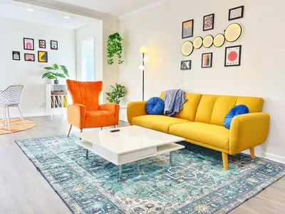 a living room with a yellow couch and two orange chairs at Groovy Getaway Retro Vibes in North Park, SD in San Diego