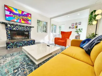 a living room with a yellow couch and a fireplace at Groovy Getaway Retro Vibes in North Park, SD in San Diego