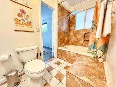 a bathroom with a toilet and a tub at Groovy Getaway Retro Vibes in North Park, SD in San Diego