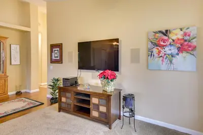 a living room with a television and a vase of flowers at Peaceful El Cajon Vacation Rental with Patio and Yard! in El Cajon