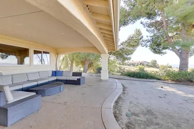 a patio with couches and tables on a building at Charming Temecula Home with Hot Tub, Mountain Views! in Temecula