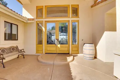 a house with a yellow door and a bench at Charming Temecula Home with Hot Tub, Mountain Views! in Temecula