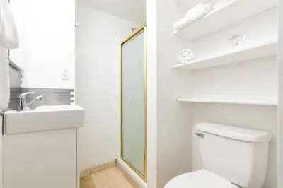 a bathroom with a toilet and a sink and a mirror at Spacious Ocean View Blufftop Compound in San Clemente