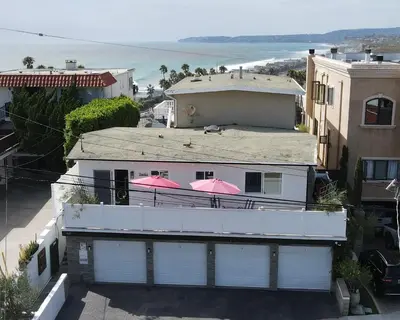 a white house with pink umbrellas on top of it at Panoramic Ocean View Cottage and Hideaway Unit #4 and B in San Clemente