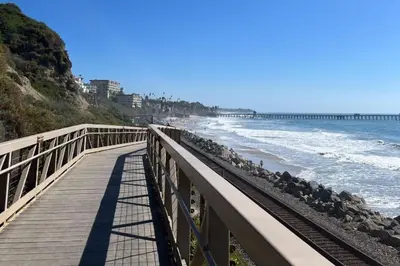a boardwalk leading to the beach with a pier at Panoramic Ocean View Cottage and Hideaway Unit #4 and B in San Clemente