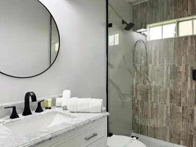 a bathroom with a shower and a sink and a mirror at Panoramic Ocean View Cottage and Hideaway Unit #4 and B in San Clemente