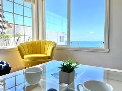 a yellow chair sitting in a room with a glass table at Ocean View Hideaway Unit #3 in San Clemente