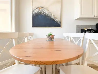 a wooden table in a kitchen with white chairs at Ocean View Hideaway Unit #3 in San Clemente