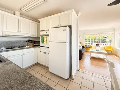 a kitchen with white cabinets and a white refrigerator at Ocean View Hideaway Unit #3 in San Clemente