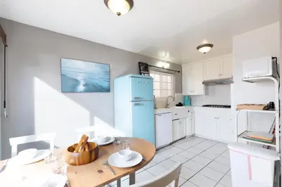 a kitchen with a wooden table and a blue refrigerator at Sea View Escape Unit #2 in San Clemente