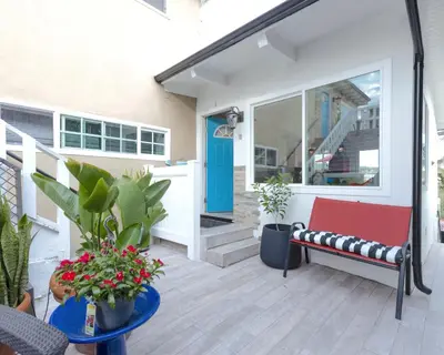 a porch with a red bench and a blue door at Bright Ocean View Escape Unit #1 in San Clemente
