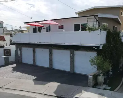a house with four garage doors and a balcony at Bright Ocean View Escape Unit #1 in San Clemente