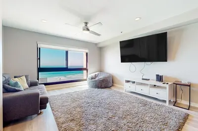 a living room with a couch and a flat screen tv at Blue Wave Penthouse in San Diego