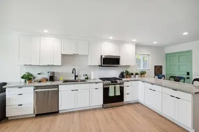 a kitchen with white cabinets and a stove top oven at Coastal Living at its Finest Pacific Beach in San Diego