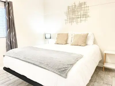 a white bedroom with a bed with white sheets and pillows at Modern Retreat Just Outside The City in San Diego
