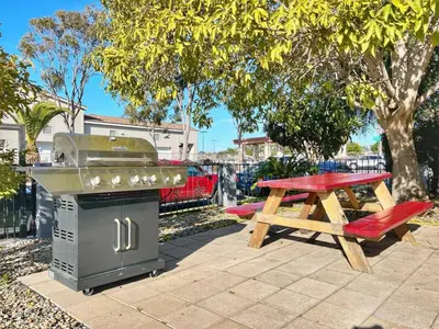 a picnic table and a grill and a picnic table at Charming Flat Near the City in San Diego