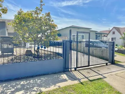 a fence with a blue gate in a yard at Charming Flat Near the City in San Diego