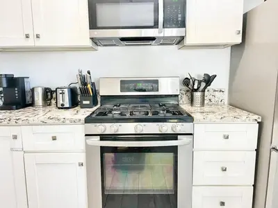 a kitchen with a stove and a microwave at Charming Flat Near the City in San Diego
