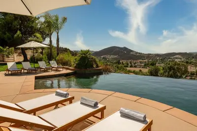 a swimming pool with lounge chairs and a swimming pool at Vineyard View by Fieldtrip 8 Bd with Infinity Pool Hot Tub Games in Lake Elsinore