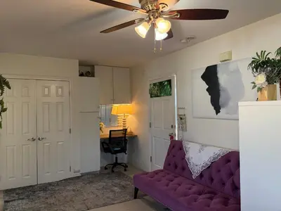 a living room with a purple couch and a ceiling fan at Min to Downtown/Beach/Parks Free Parking Sleep 3+ in San Diego