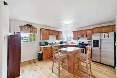 a kitchen with wooden cabinets and a white refrigerator at Paradise On Earth residence in Lake Elsinore