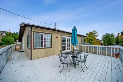 a deck with a table and chairs and an umbrella at Paradise On Earth residence in Lake Elsinore