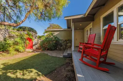 two red chairs sitting on the porch of a house at CBS-501 - Cardiff Hillside Hideaway in Cardiff-by-the-Sea