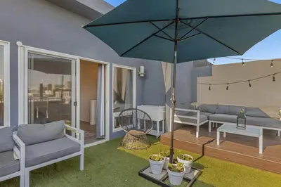 a patio with a blue umbrella on a deck at 4BR Spectacular Harbor View Modern Home 5min Zoo in San Diego