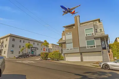 a plane is flying over a street with a building at 4BR Spectacular Harbor View Modern Home 5min Zoo in San Diego