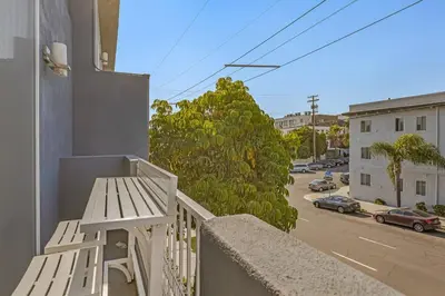 a white bench sitting on a balcony with a street at 4BR Spectacular Harbor View Modern Home 5min Zoo in San Diego