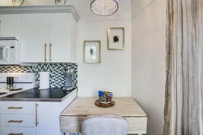 a kitchen with white cabinets and a wooden table at Cozy Alpine Cottage Near Casinos and Trails! in Alpine