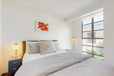 a white bedroom with a bed and a window at Seaside Serenity Haven -30 night min in San Diego