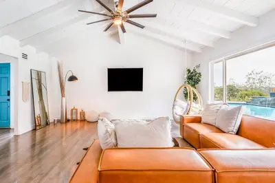 a living room with a couch and a tv at Amazing Views with Heated Pool and Jacuzzi Near Beach in Solana Beach