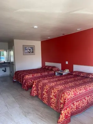 a hotel room with two beds and a red wall at Star Lodge Motel-Vista Oceanside in Vista