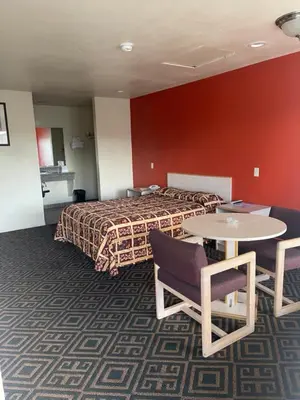 a hotel room with a bed and a table and chairs at Star Lodge Motel-Vista Oceanside in Vista