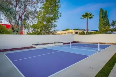 a tennis court with a tennis racket on it at Pickleball Paradise by Rather Be Properties in Mission Viejo
