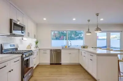 a kitchen with white cabinets and a stove top oven at Pickleball Paradise by Rather Be Properties in Mission Viejo