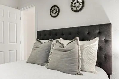 a bed with pillows and two clocks on the wall at Brand New home in San Diego 3BR Quiet neighborhood near Downtown/Seaworld/Zoo in San Diego