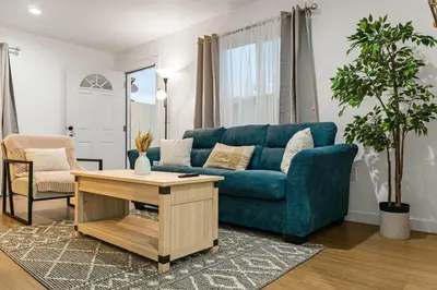 a living room with a blue couch and a table at Brand New home in San Diego 3BR Quiet neighborhood near Downtown/Seaworld/Zoo in San Diego